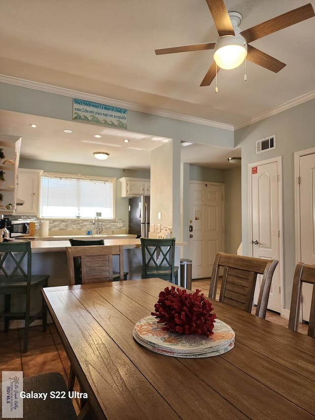 dining room featuring crown molding and ceiling fan