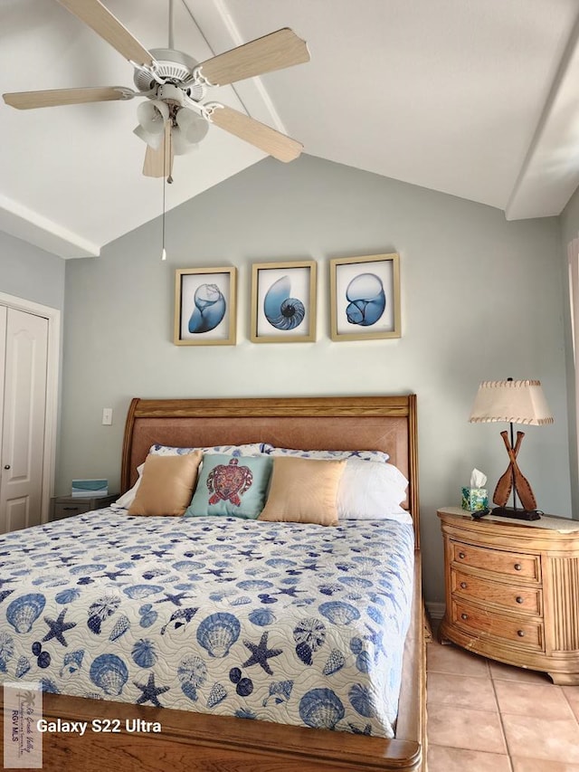 tiled bedroom featuring a closet, ceiling fan, and lofted ceiling