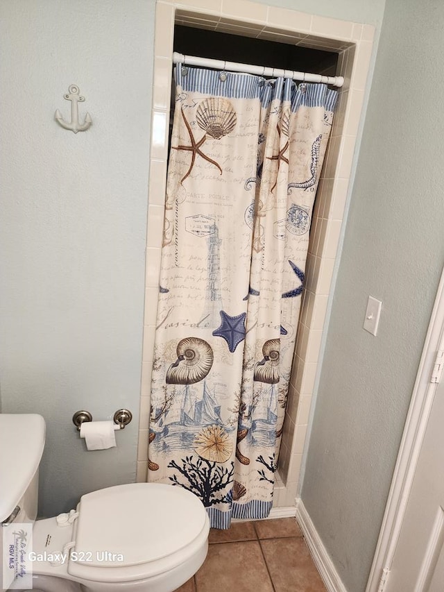 bathroom featuring a shower with shower curtain, tile patterned floors, and toilet