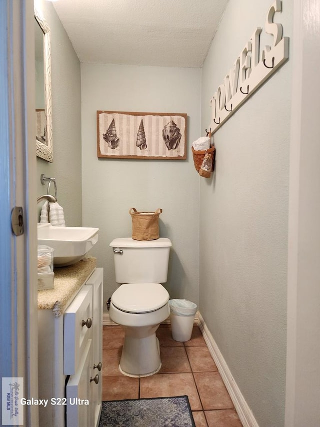 bathroom featuring tile patterned floors, vanity, a textured ceiling, and toilet