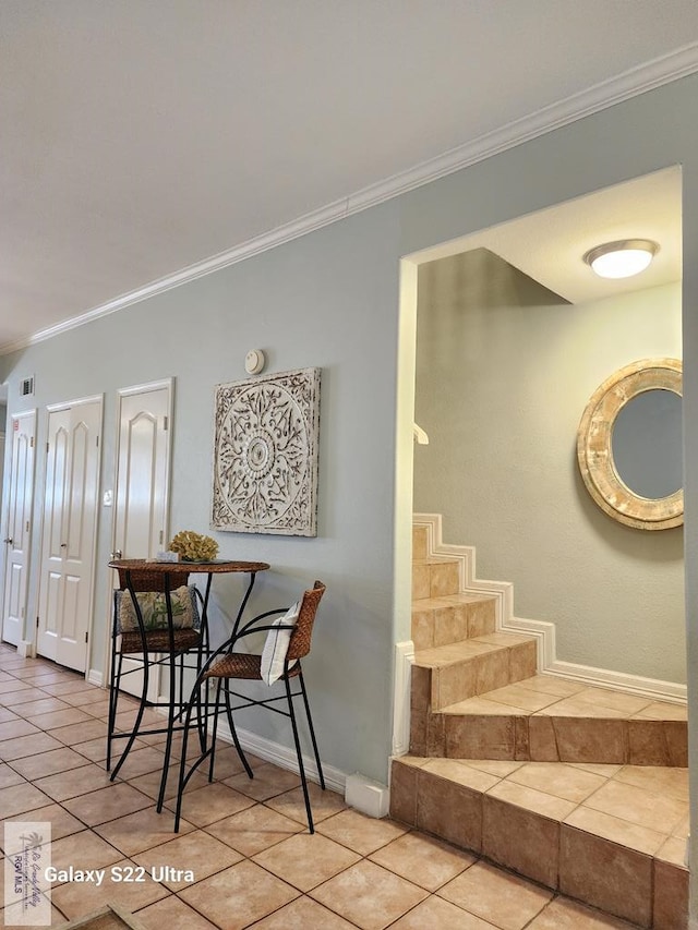 tiled dining room featuring ornamental molding