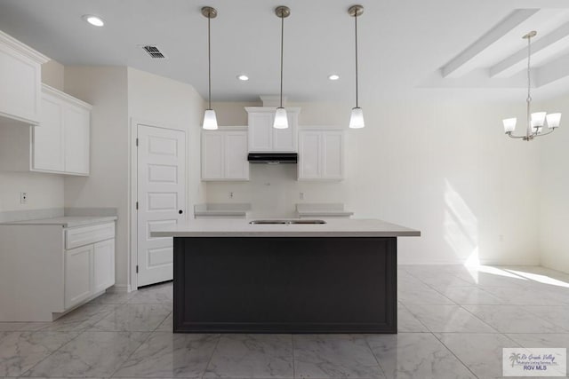 kitchen featuring a kitchen island with sink, white cabinets, and hanging light fixtures