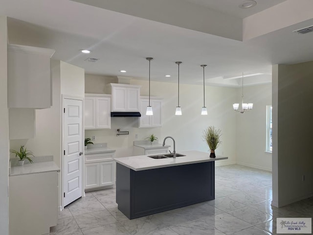 kitchen featuring pendant lighting, white cabinetry, sink, and a chandelier