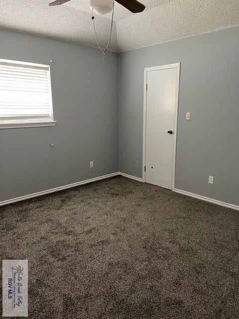 empty room featuring a textured ceiling, carpet, baseboards, and ceiling fan