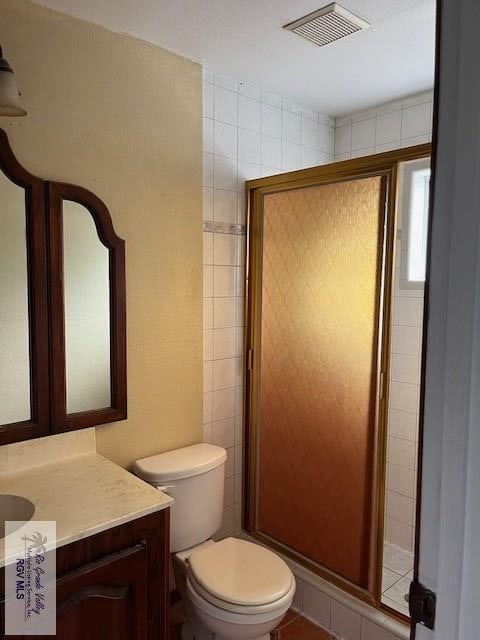 full bath with vanity, toilet, visible vents, and a stall shower