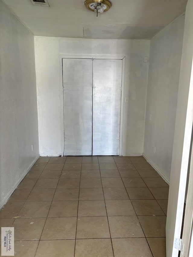 unfurnished bedroom with tile patterned flooring and a closet