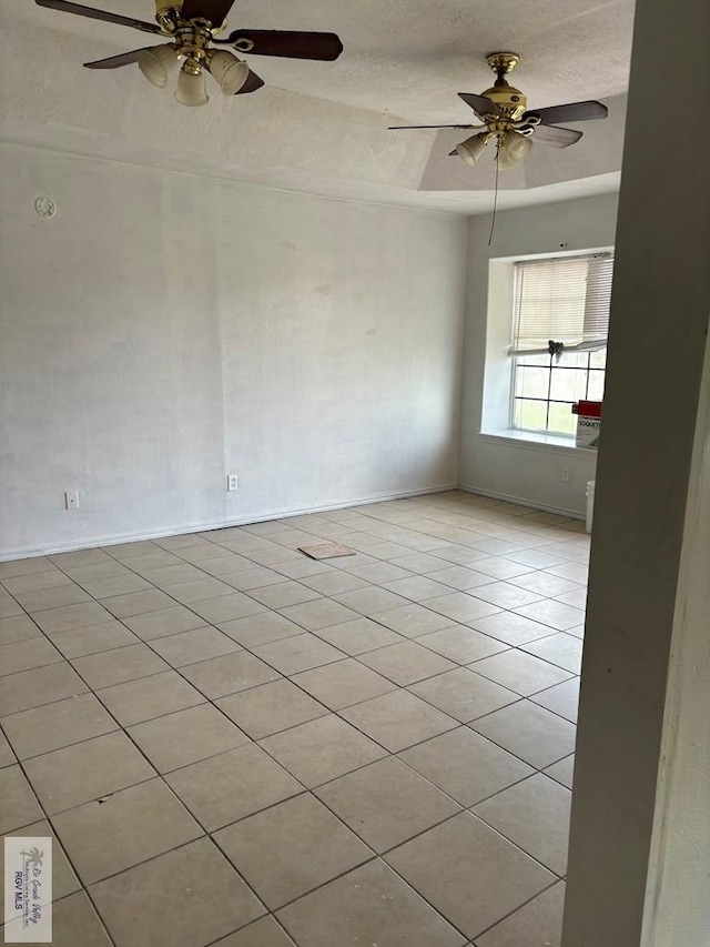 tiled spare room with ceiling fan and a textured ceiling