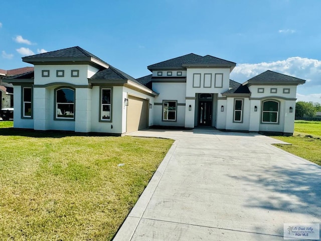 534 Billy Mitchell Blvd, Brownsville, TX 78520 - view of front of house with stucco siding, a garage, concrete driveway, a front lawn, and roof with shingles