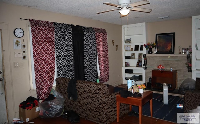 living room with a textured ceiling and ceiling fan