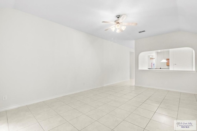 spare room with ceiling fan, light tile patterned floors, and vaulted ceiling