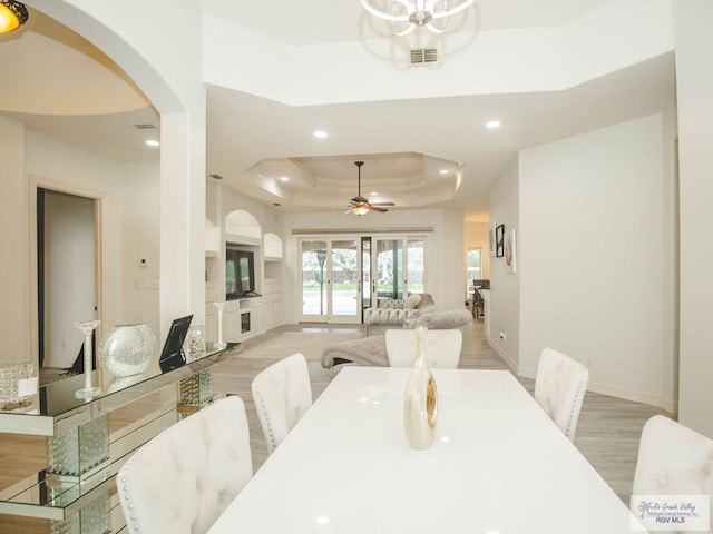 100 Paloma St, San Benito, TX 78586 - dining area with a tray ceiling, recessed lighting, light wood-style flooring, arched walkways, and a ceiling fan