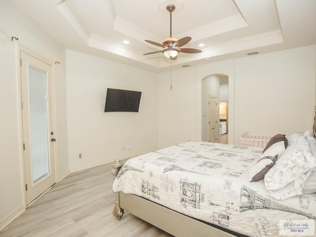 100 Paloma St, San Benito, TX 78586 - bedroom with visible vents, arched walkways, light wood-style floors, crown molding, and a raised ceiling