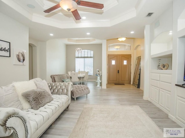 100 Paloma St, San Benito, TX 78586 - living area with arched walkways, light wood finished floors, a raised ceiling, and ornamental molding