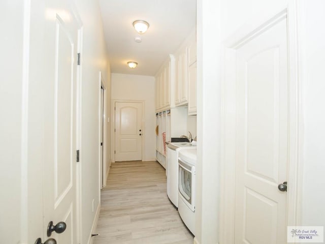 100 Paloma St, San Benito, TX 78586 - clothes washing area with cabinet space, light wood-style floors, and washer and clothes dryer