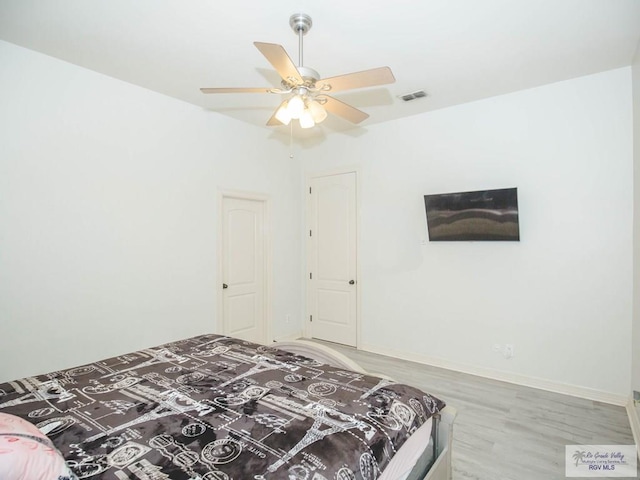 100 Paloma St, San Benito, TX 78586 - bedroom with visible vents, ceiling fan, baseboards, and wood finished floors