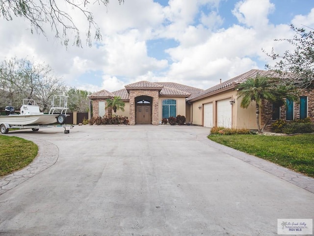 100 Paloma St, San Benito, TX 78586 - view of front of house featuring a tile roof, concrete driveway, a garage, and stucco siding