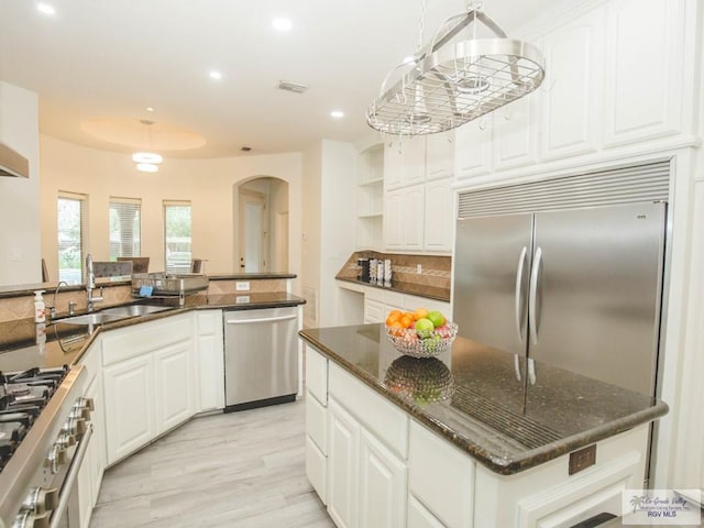 100 Paloma St, San Benito, TX 78586 - kitchen with visible vents, decorative backsplash, arched walkways, high end appliances, and a sink