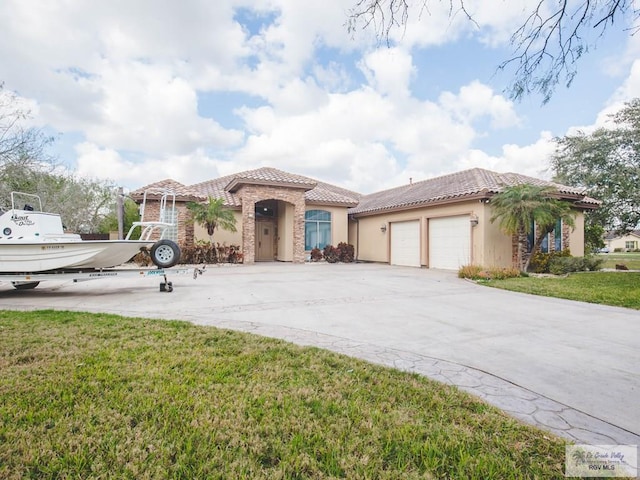 100 Paloma St, San Benito, TX 78586 - mediterranean / spanish house with a tiled roof, concrete driveway, a front yard, stucco siding, and a garage