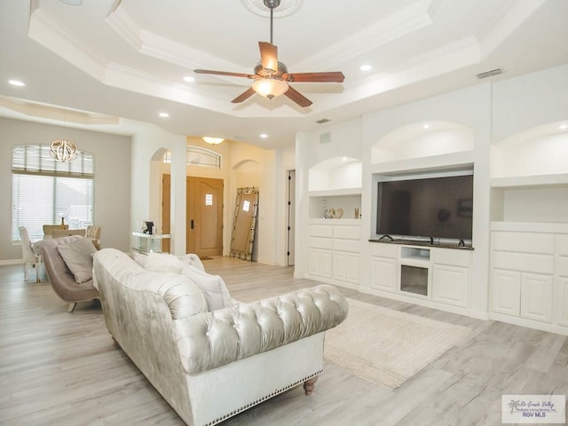 100 Paloma St, San Benito, TX 78586 - living room with a tray ceiling, built in features, visible vents, and arched walkways