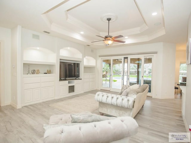 100 Paloma St, San Benito, TX 78586 - living room with light wood finished floors, ceiling fan, baseboards, a tray ceiling, and french doors