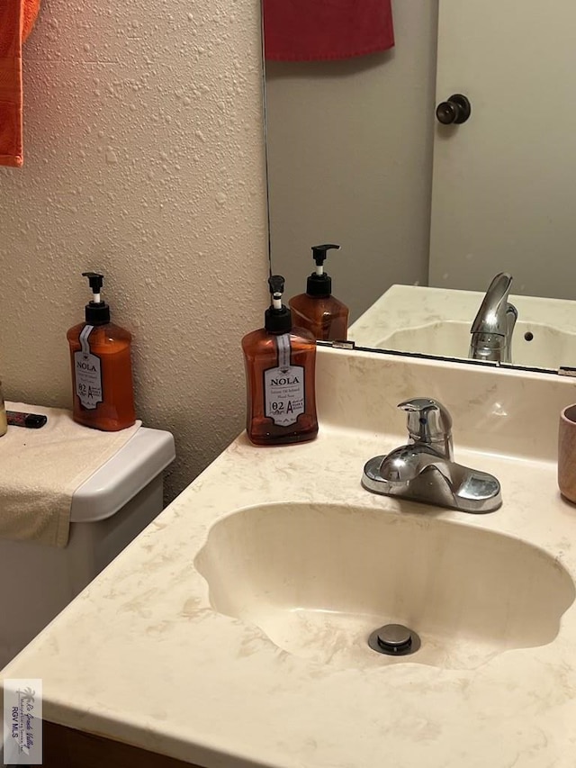 details with a textured wall and vanity