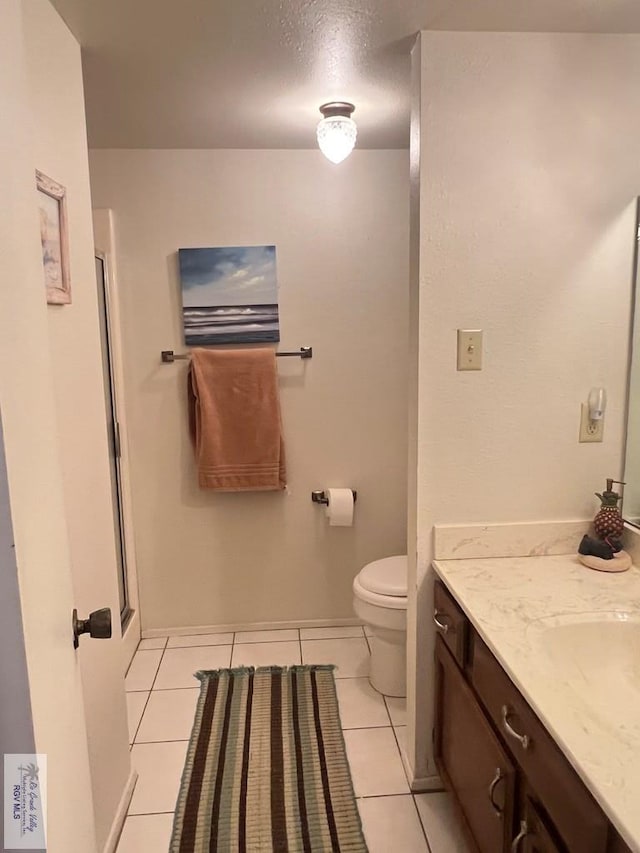 bathroom featuring tile patterned floors, vanity, and toilet