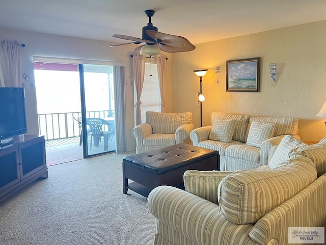 carpeted living area with a ceiling fan