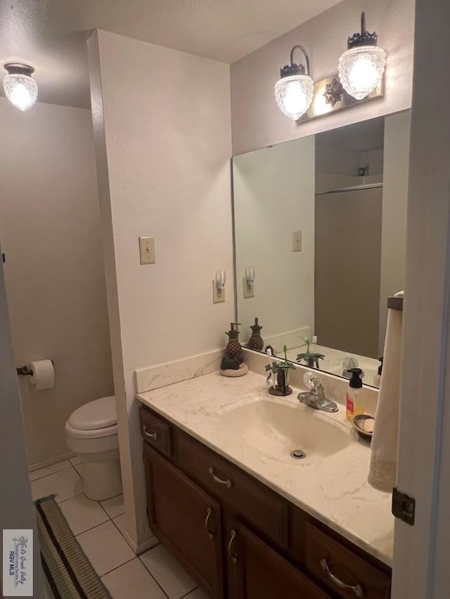 bathroom with tile patterned floors, vanity, toilet, and walk in shower