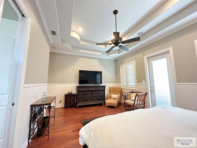 107 E Palm St Unit B, South Padre Island, TX 78597 - bedroom featuring wood finished floors, visible vents, a raised ceiling, and a wainscoted wall