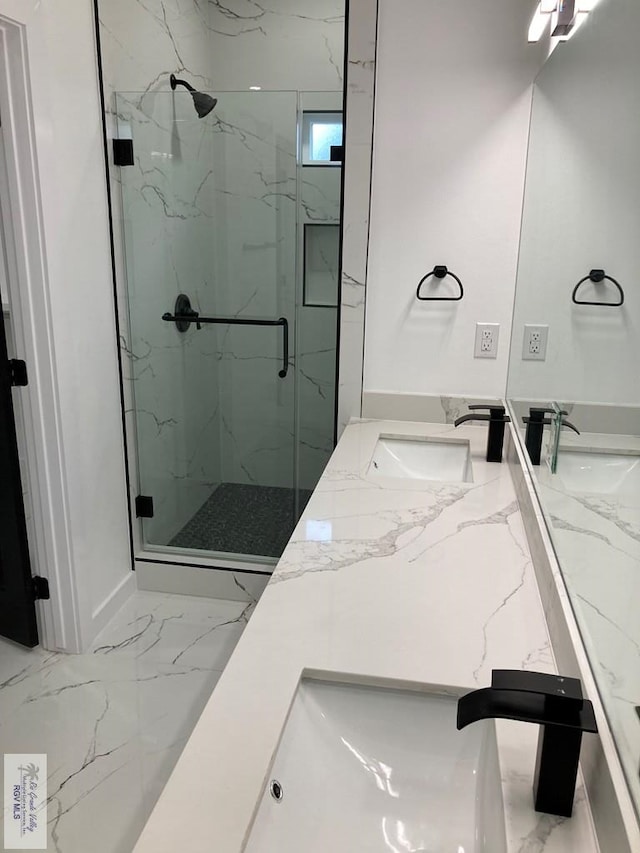 bathroom featuring a shower with door and vanity