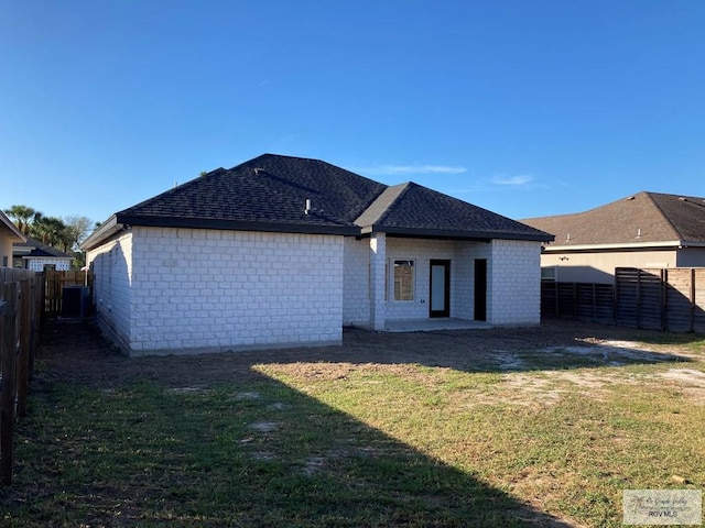 rear view of property with a patio area, a yard, and cooling unit