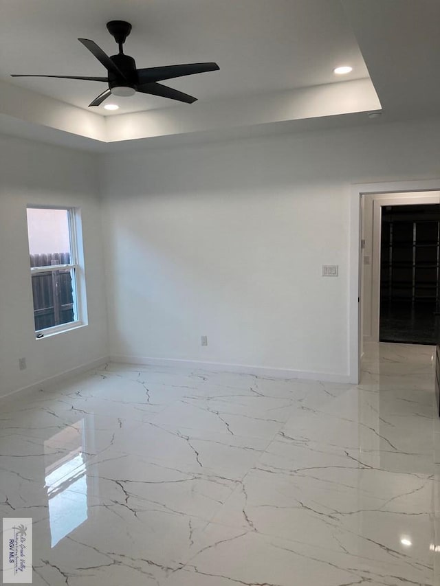 unfurnished room with a raised ceiling and ceiling fan