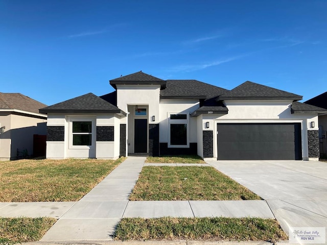 prairie-style home with a garage and a front lawn