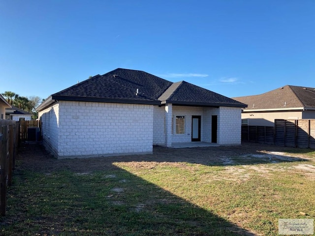 back of property with a yard and central AC unit