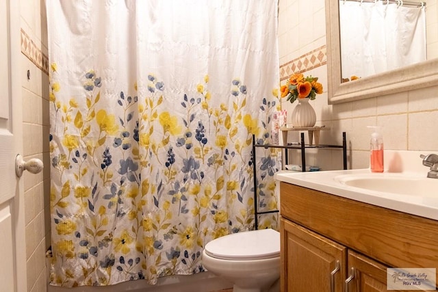 bathroom with vanity, toilet, tile walls, walk in shower, and tasteful backsplash