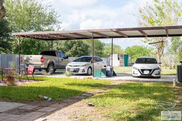 view of parking with a lawn and a carport