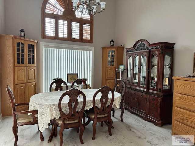 dining space featuring a high ceiling and a chandelier