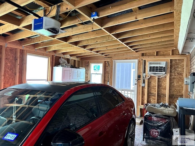 garage with a wall mounted air conditioner and a garage door opener