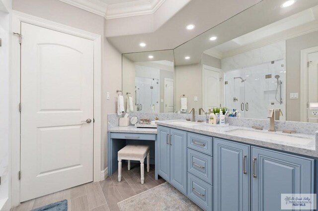 bathroom with crown molding, vanity, and walk in shower