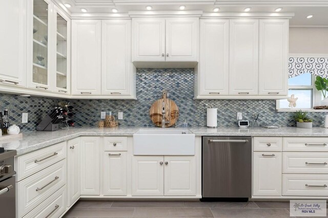 kitchen featuring white cabinetry, light stone countertops, appliances with stainless steel finishes, and tasteful backsplash