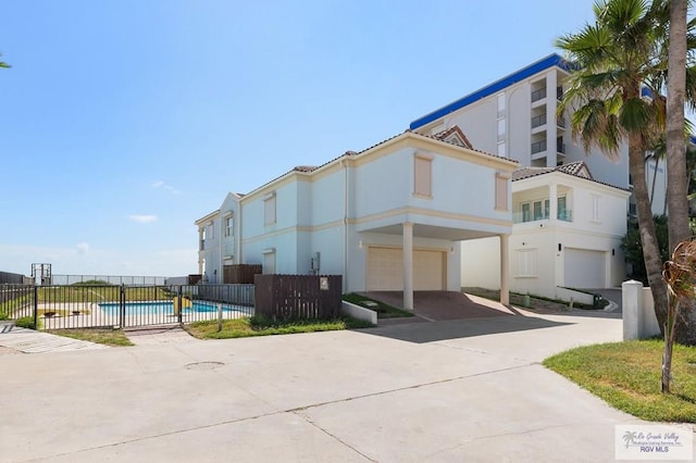 exterior space with a fenced in pool and a garage