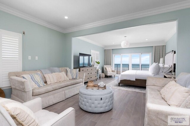 bedroom with access to outside, hardwood / wood-style floors, and ornamental molding