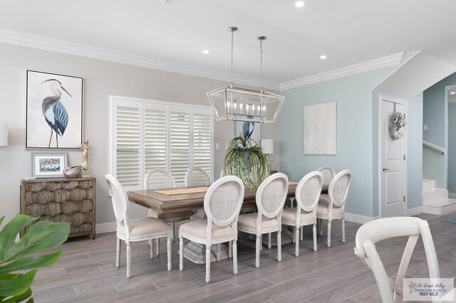 dining space featuring crown molding, light hardwood / wood-style flooring, and a chandelier