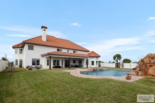 back of property featuring a yard, a fenced in pool, and a patio area