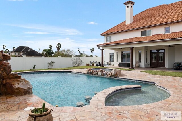 view of pool featuring an in ground hot tub, french doors, pool water feature, ceiling fan, and a patio area