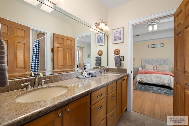 bathroom featuring a skylight, a shower with curtain, vanity, ceiling fan, and hardwood / wood-style flooring