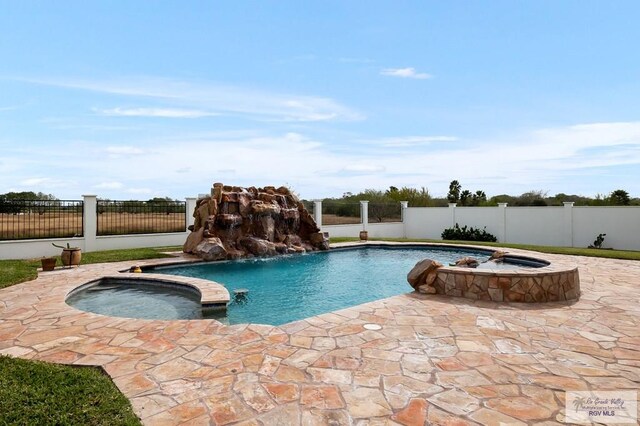 view of pool with pool water feature, an in ground hot tub, and a patio