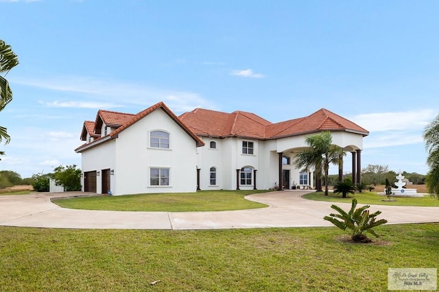 mediterranean / spanish-style house featuring a garage and a front lawn