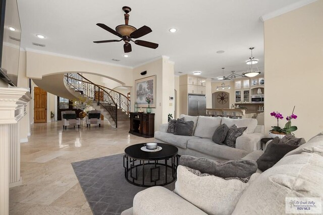 living room with ceiling fan and ornamental molding