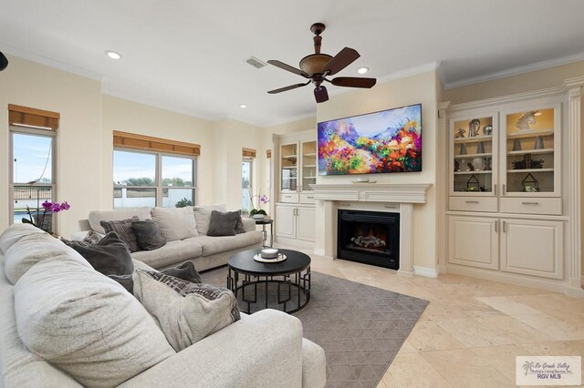 living room with ceiling fan and ornamental molding